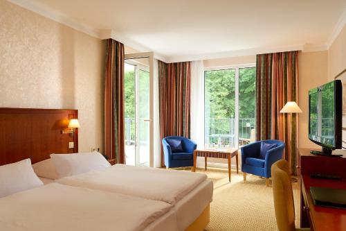 une chambre d'hôtel avec un lit, une table et des chaises dans l'établissement Grand Hotel Binz, à Binz