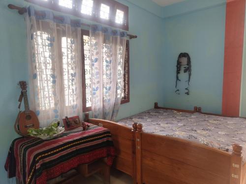um quarto com uma cama e uma guitarra em Tales of Guwahati em Guwahati