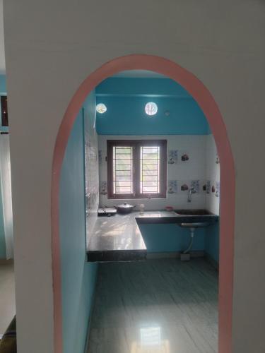 einen Torbogen im Bad mit einem Waschbecken und einem Fenster in der Unterkunft Tales of Guwahati in Guwahati