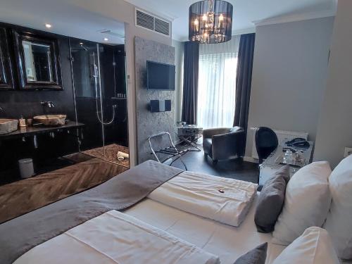 a bedroom with a large bed and a bathroom at Villahotel Rheinblick in Cologne