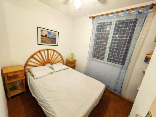une petite chambre avec un lit et une fenêtre dans l'établissement Villa mitoyenne avec piscine, parking, climatisation et proche mer, idéale pour 4 personnes - FR-1-607-89, au Cap d'Agde