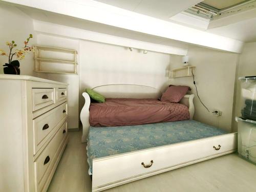 - une petite chambre avec un lit et une commode dans l'établissement Charmant T2 Mezzanine Climatisé, 4 Pers avec Terrasse et Parking - Proche Plages et Commerces - FR-1-607-134, au Cap d'Agde