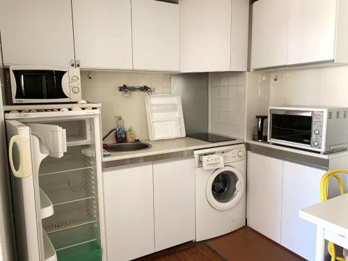 une cuisine avec des armoires blanches et une laveuse et une sécheuse dans l'établissement Charmant T2 Mezzanine Climatisé, 4 Pers avec Terrasse et Parking - Proche Plages et Commerces - FR-1-607-134, au Cap d'Agde