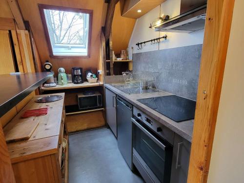 une petite cuisine avec un évier et une cuisinière dans l'établissement Chalet 5 personnes, proche ski et rando, balcon sud, TV, lave-linge - FR-1-393-165, à Saint-Michel-de-Chaillol