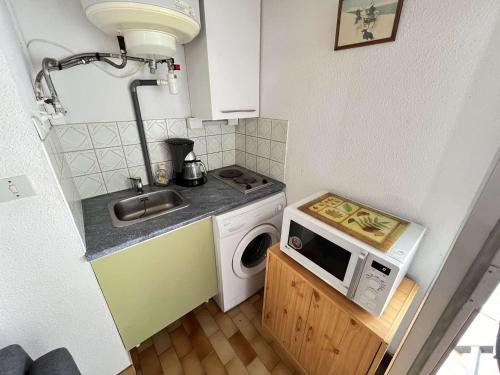 une petite cuisine avec un évier et une machine à laver dans l'établissement Studio Cabine avec Mezzanine, Ascenseur, Commerces à Proximité, Lave-Linge, Animaux Admis - FR-1-702-29, au Cap d'Agde