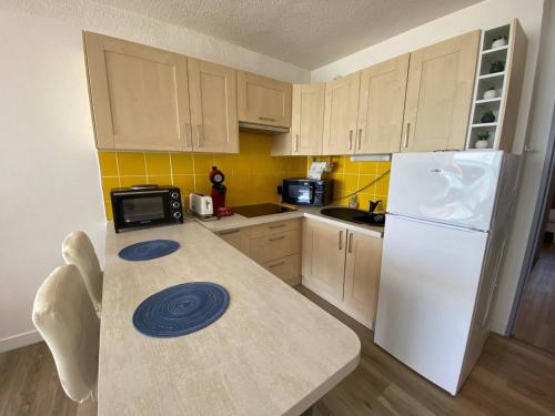une cuisine avec un réfrigérateur blanc et un plan de travail dans l'établissement Appartement T3 rénové, 6 pers, face mer, parking, balcon, proche plages - FR-1-81-583, au Barcarès
