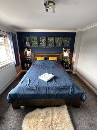 um quarto com uma cama azul e uma cabeceira azul em Music lovers house em Morley