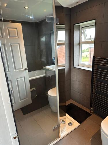 uma casa de banho com um chuveiro, um WC e um lavatório. em Music lovers house em Morley