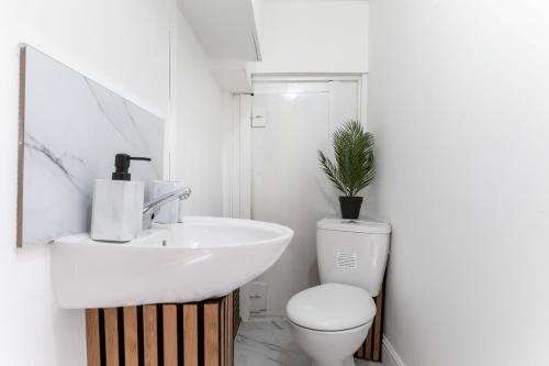 a white bathroom with a sink and a toilet at 3 bedroom house in Notting Hill in London