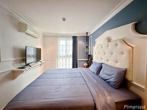 a bedroom with a large bed and a television at Jomtien Beach, Pattaya - Seven Seas Côte d'Azur in Na Jomtien