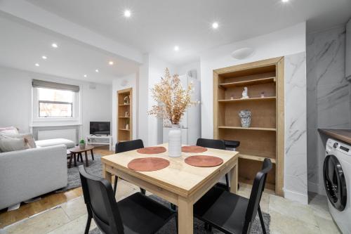 a kitchen and living room with a wooden table and chairs at 3 bedroom house in Notting Hill in London