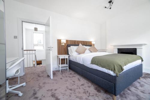 a bedroom with a large bed and a fireplace at 3 bedroom house in Notting Hill in London