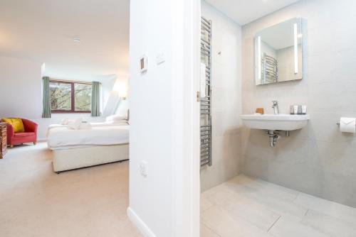 baño blanco con lavabo y cama en Trewern Arms Hotel, en Newport