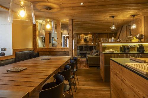 une cuisine avec une grande table et des chaises en bois dans l'établissement Savoielac - La Clusaz - Centre du village : Appartement Clusaz Coeur, à La Clusaz