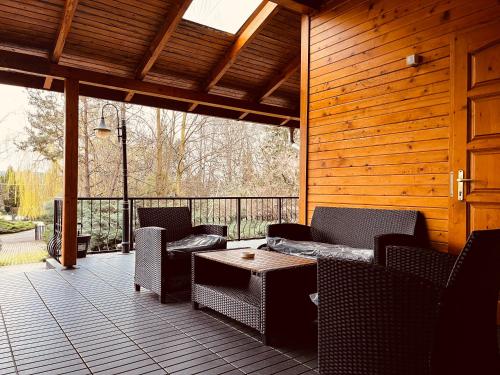 eine Terrasse mit Stühlen, einem Sofa und einem Tisch in der Unterkunft Favilla DELUXE Bogács in Bogács