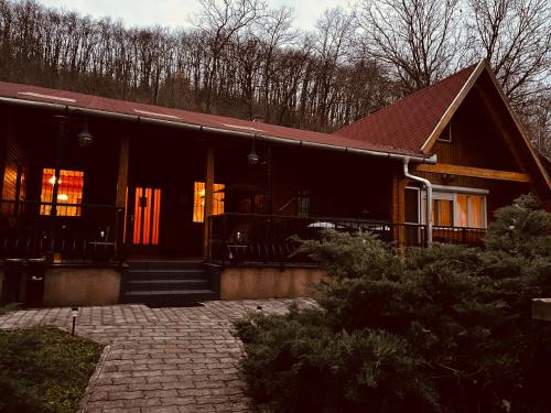 ein Haus mit einer roten Tür und einer Veranda in der Unterkunft Favilla DELUXE Bogács in Bogács