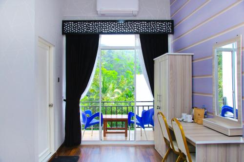 Cette chambre dispose d'une grande fenêtre et d'une table avec des chaises. dans l'établissement CROWN REGENCY- BADULLA, à Badulla