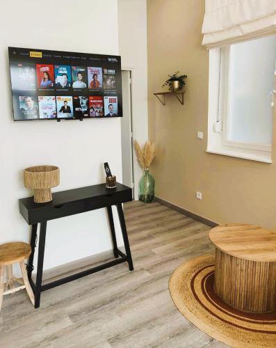 ベルク・シュル・メールにあるOpale Dunes T2 à 200m Plage Dunes WIFI BALNÉO-SPA 4 PERS Garage PRIVÉのリビングルーム(テーブル、壁掛けテレビ付)