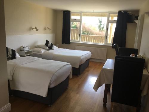 a hotel room with two beds and a window at La Mirage B&B in Bantry