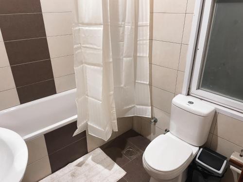 Airport West 3BR apartment في آكرا: حمام مع مرحاض ومغسلة وحوض استحمام