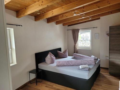 een slaapkamer met een bed met roze kussens erop bij Zur Tilli in Neustift im Stubaital