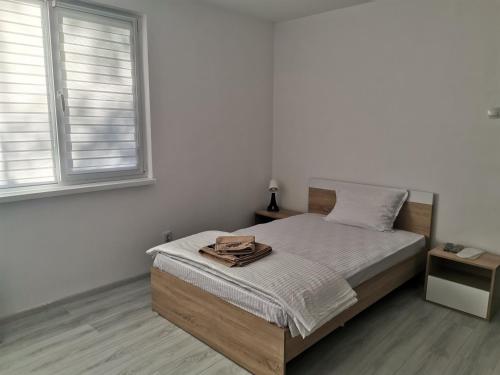 ein Schlafzimmer mit einem Bett und zwei Fenstern in der Unterkunft Дива in Kardschali
