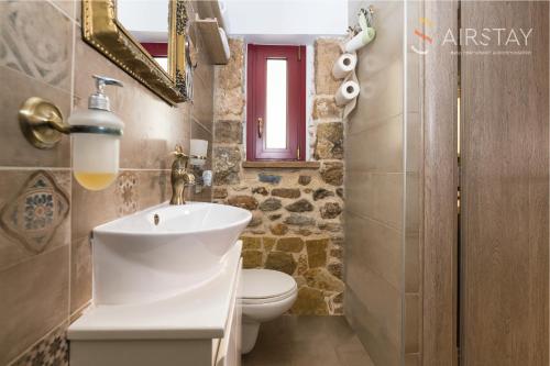 a bathroom with a sink and a toilet and a mirror at Orianna Apartment Airport by Airstay in Spata