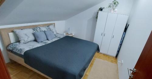 a bedroom with a bed with blue sheets and pillows at Apartman Panorama in Požarevac