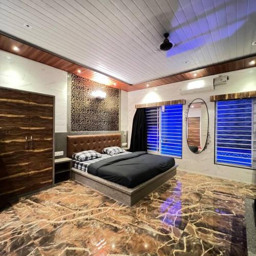 Schlafzimmer mit einem großen Bett und Steinboden in der Unterkunft Imagine star in Lonavla