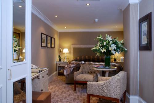 a living room with a couch and a table with flowers at The Montague On The Gardens in London