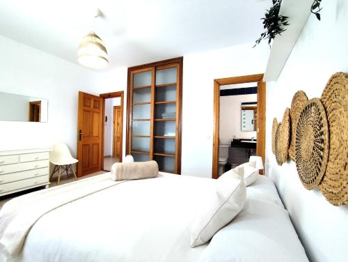 a white bedroom with a large bed and a desk at Villas Rodríguez in Playa Blanca