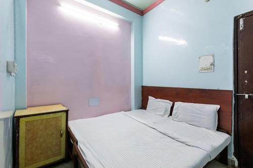 Dormitorio pequeño con cama con cabecero de madera en Vanilla hotel, en Bhopal