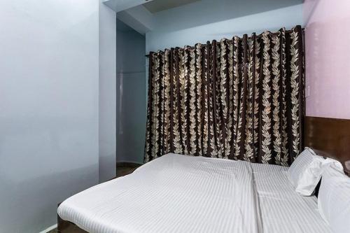1 dormitorio con cama y ventana con cortina en Vanilla hotel, en Bhopal