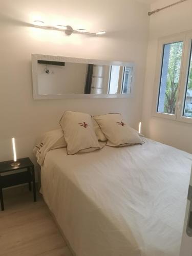 une chambre avec un lit blanc avec deux oreillers dans l'établissement JIMMYS HOUSE 55, à Beausoleil