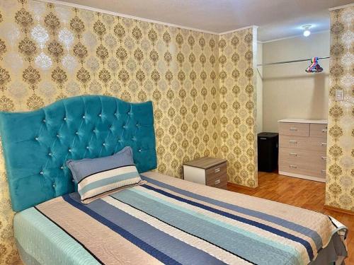 Bett mit blauem Kopfteil in einem Schlafzimmer in der Unterkunft Departamento 2 habitaciones a 5 min del centro in Trujillo