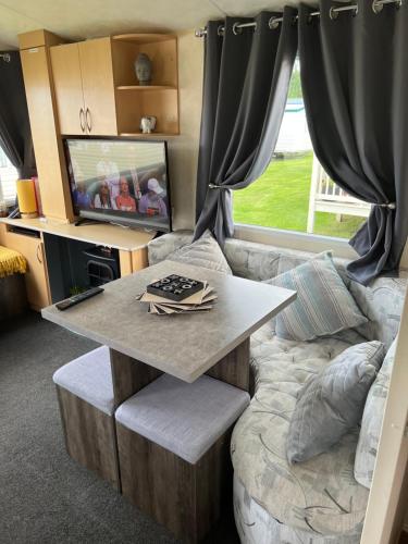a living room with a table and a couch at Northumberland Caravan Holiday in Cresswell