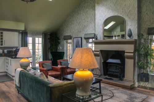 a living room with a couch and a fireplace at The Hollies Forest Lodges in Cuddington