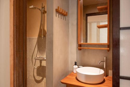 W łazience znajduje się biała umywalka i prysznic. w obiekcie Cepoun - Grand studio centre Saint-Tropez w Saint-Tropez