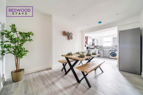 uma sala de jantar com uma mesa e um vaso de plantas em BRAND NEW, 2 Bed 1 Bath, Modern Town Center Apartment, FREE WiFi & Netflix By REDWOOD STAYS em Aldershot