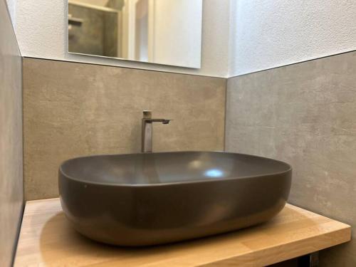 a large brown sink on a wooden counter in a bathroom at Regina design apartment Lugano in Lugano