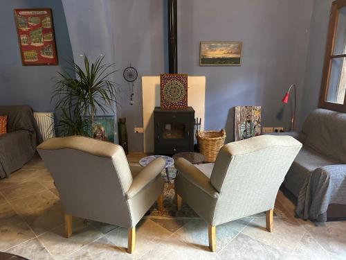 a living room with two chairs and a fireplace at Teleport Coliving Cyprus in Pano Lefkara