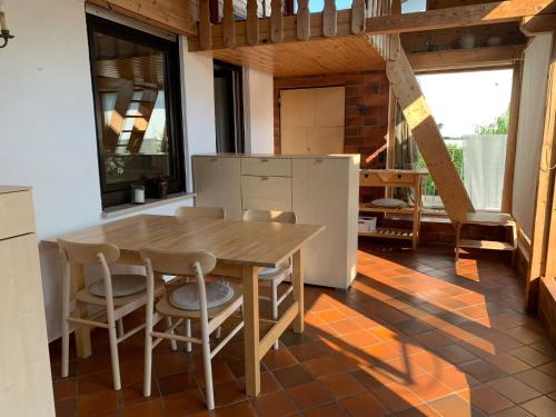a kitchen with a wooden table and chairs at Ferienwohnung Blick ins Grüne in Ober-Ramstadt