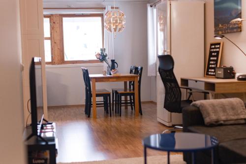 een woonkamer met een tafel en stoelen bij Cozy and central among locals in Tromsø