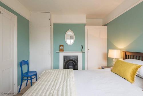 - une chambre avec un lit, une chaise et une cheminée dans l'établissement Prince's Cottage, à Deal