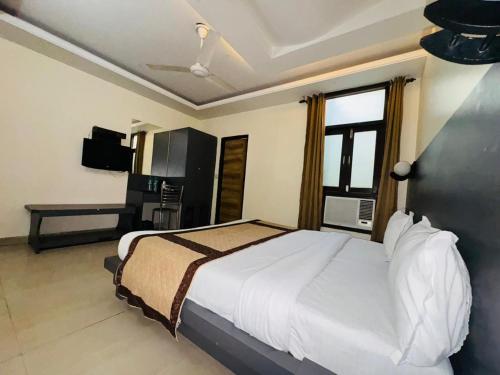 a bedroom with a large bed and a television at Hotel Airport Stay - Near Terminal 3 in New Delhi