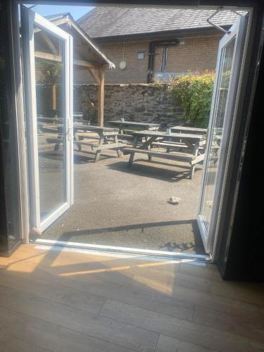 an open door with a bunch of picnic tables behind it at Prince of wales accommodation in Llangollen