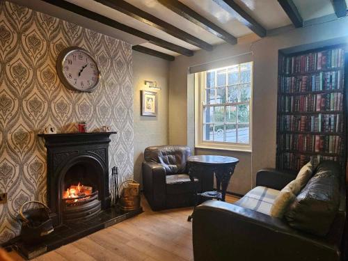 a living room with a fireplace and a clock on the wall at Prince of wales accommodation in Llangollen