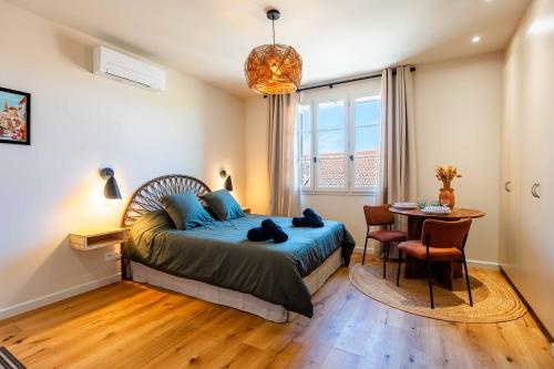 a bedroom with a bed and a table and a window at OUSTAU DE MARIE in Saint-Rémy-de-Provence