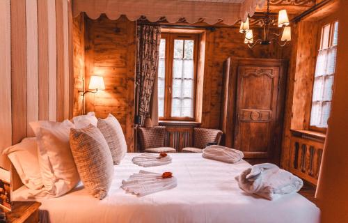 a bedroom with a bed with white sheets and pillows at Les Violettes Hotel & Spa in Jungholtz