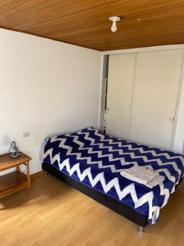 Habitaciones tranquilas en Usaquen para viajeros في بوغوتا: غرفة نوم بسرير ازرق وبيض في غرفة